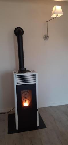 a stove in a room with a fire in it at Maison Bourbonnaise idéalement placée proche du centre ville de Moulins in Neuvy
