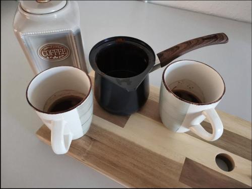 two cups of coffee sitting on a cutting board at Unique studios near Tivoli in Ljubljana