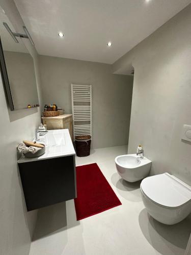 een badkamer met een toilet, een bidet en een rood kleed bij Appartamento ad Orvieto in Orvieto