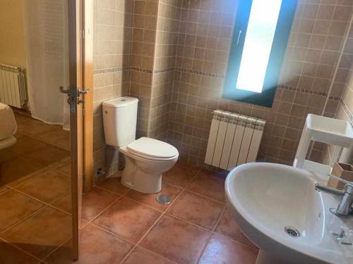 La salle de bains est pourvue de toilettes et d'un lavabo. dans l'établissement Villas Rurales Arroyovil, à Mancha Real