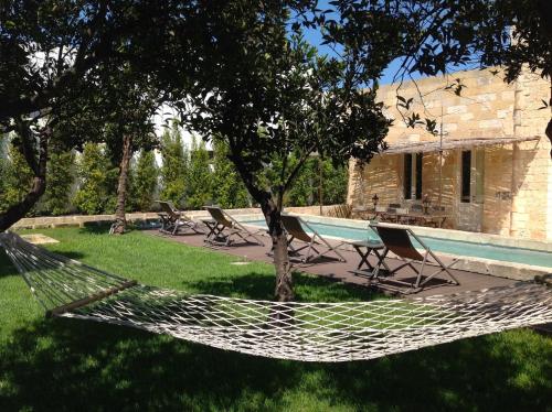a hammock in a yard next to a house at Antica Dimora Giardini Segreti in Giuggianello
