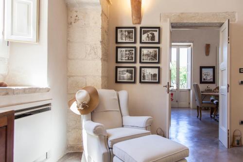 a living room with a chair and pictures on the wall at Antica Dimora Giardini Segreti in Giuggianello