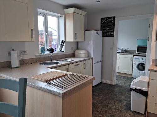 Una cocina con gabinetes blancos y encimera. en Sea Escape The Tardiis Beachfront location Aberavon beach Sea Views Driveway parking, en Port Talbot