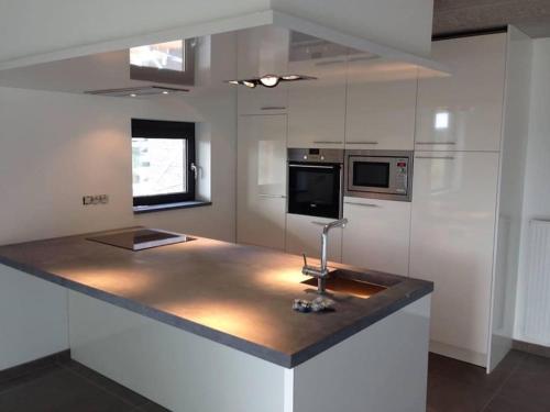 a kitchen with a counter with a microwave and a stove at Appartement à Courrière in Assesse
