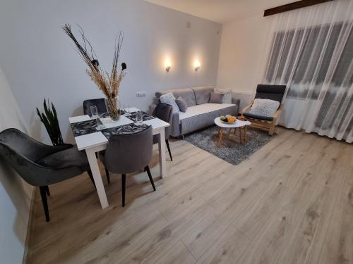 een woonkamer met een bank en een tafel bij Apartmani "Vila Jelena" Arandjelovac in Arandjelovac
