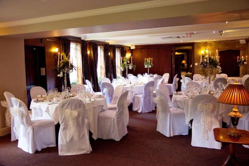 a room filled with tables and chairs with white table cloth at Whitley Hall Hotel in Chapeltown
