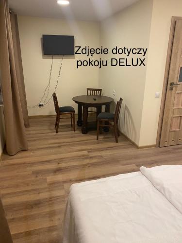 a room with a table and chairs and a tv at Leśna Polana in Sękocin Stary