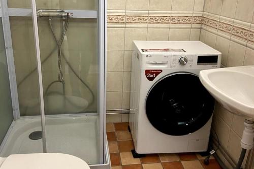 a washing machine in a bathroom next to a sink at central apartment with free parking in Huskvarna