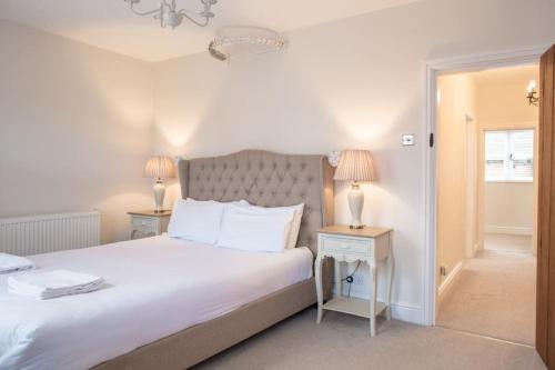 a bedroom with a large white bed with two lamps at Charming 2 Bed House in Tewkesbury Centre in Tewkesbury