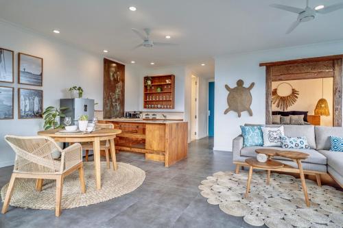 ein Wohnzimmer mit einem Sofa und einem Tisch in der Unterkunft Angel Bay Beach House - Ulus Tropical 1 Bedroom Ocean View Apartment in Tanah Lot