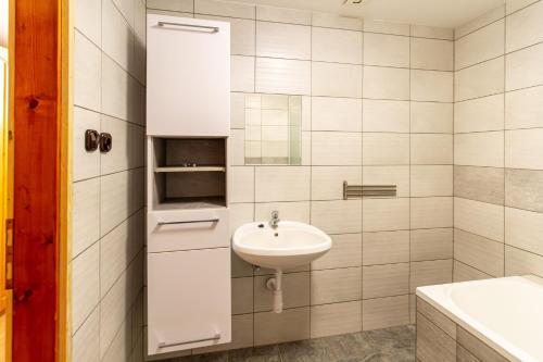 a white bathroom with a sink and a toilet at Déli Terasz B Apartman Free parking, self-check-in anytime in Győr