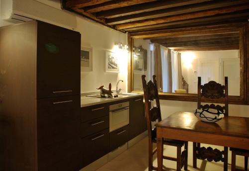 cocina con fregadero, mesa y nevera en Appartamento Corte Bragadin, en Venecia