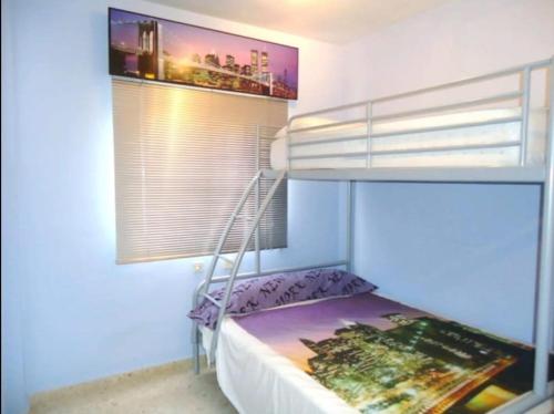 1 dormitorio con litera y ventana en CHIPIONA SOL Y PLAYA, en Chipiona