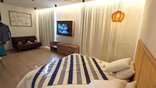 a bedroom with a bed and a tv and a couch at Intense Boutik-Hôtel in Port-Vendres