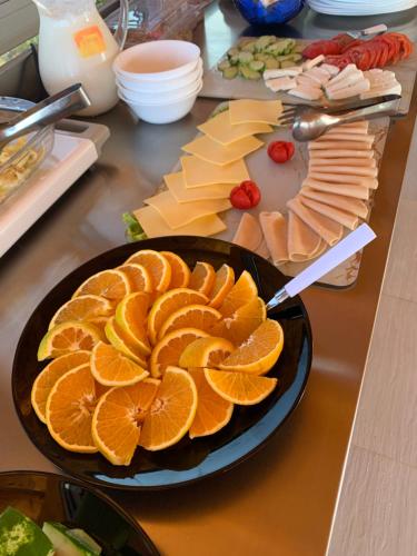 Dream Hotel في كساميل: طاولة مع صحن من البرتقال والأطعمة الأخرى