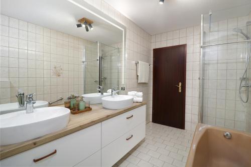 uma casa de banho com 2 lavatórios e um chuveiro em Ferienwohnung mit exklusiver Aussicht im Wander- und Bikeparadies Schwarzwald em Donaueschingen