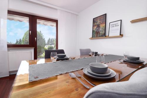 a dining room with a table with dishes on it at Apartment Kneer - Panoramic View & Private Garden near Black Forest & Lake Constance in Donaueschingen