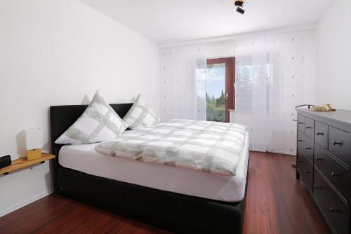a bedroom with a bed and a dresser at Ferienwohnung Kneer Donaueschingen in Donaueschingen