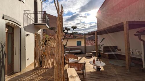 a balcony with a table and chairs on a building at Intense Boutik-Hôtel in Port-Vendres