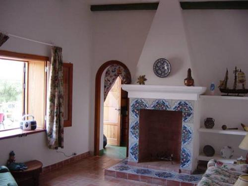 
a living room with a fireplace and a window at Torre di Scopello in Scopello
