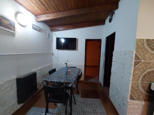 comedor con mesa y TV en la pared en Alquileres temporarios Anahi, en Las Heras