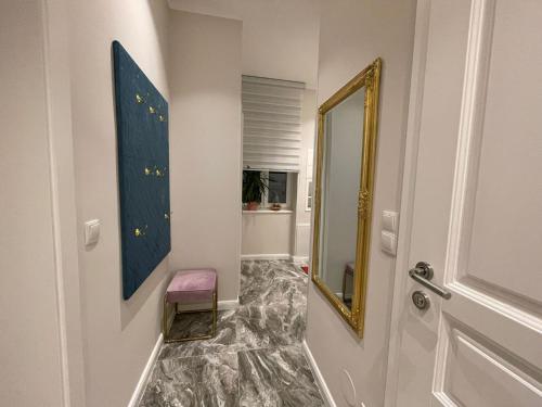 a hallway with a mirror and a stool next to a door at Herz von Wien Mariahilfer in Vienna