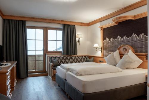 a hotel room with two beds and a window at Hotel Glöckner und Hotel Residenz Glöckner in Ischgl