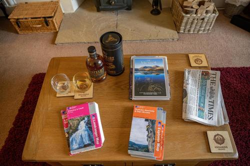 a wooden table with magazines and books on it at Edengrove in Aberfeldy