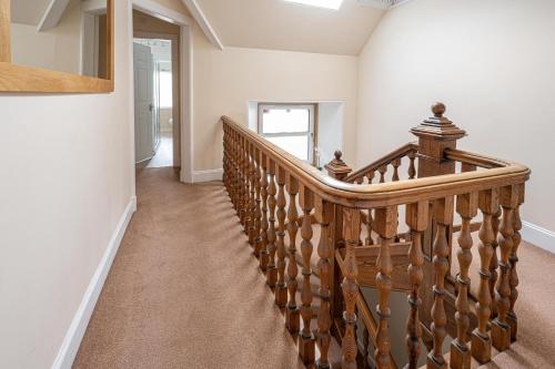 a wooden staircase in a home with white walls at Edengrove in Aberfeldy