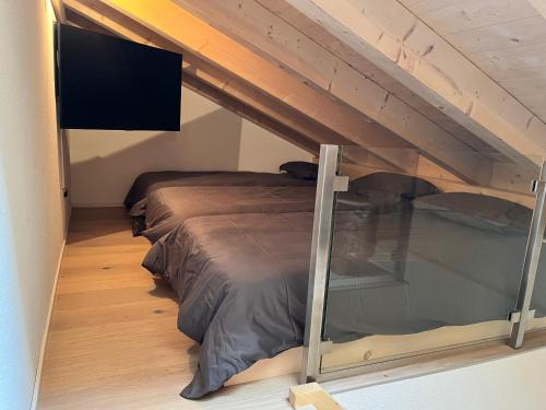 a bedroom with a bed and a flat screen tv at Klosters/Davos - topfloor luxury apartment with extraordinary views in Klosters Dorf