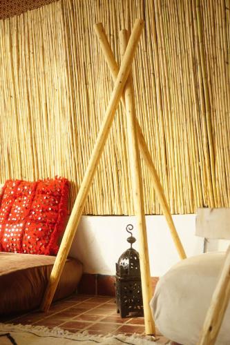 a bed in a room with a curtain at Caban Surf in Tamraght Ouzdar