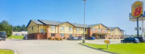 a large building with cars parked in a parking lot at Super 8 by Wyndham Warrenton in Warrenton