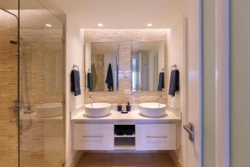 La salle de bains est pourvue de 2 lavabos et d'une douche. dans l'établissement Punta Palmera ocean views 1bed apartment Cap Cana, à Punta Cana