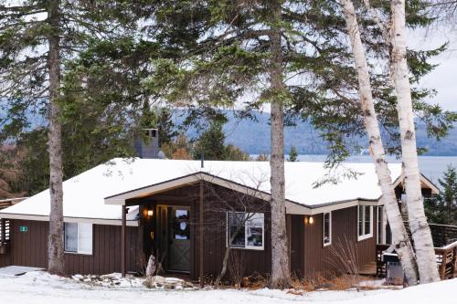 a house covered in snow with trees at Rangeley Lake House, lake access, Saddleback 15min in Rangeley