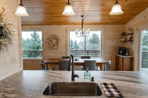 a kitchen with a sink and a dining room at Rangeley Lake House, lake access, Saddleback 15min in Rangeley