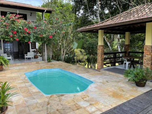 a swimming pool in the middle of a patio at Casa Barlavento com Piscina e Praia em Angra - RJ in Angra dos Reis