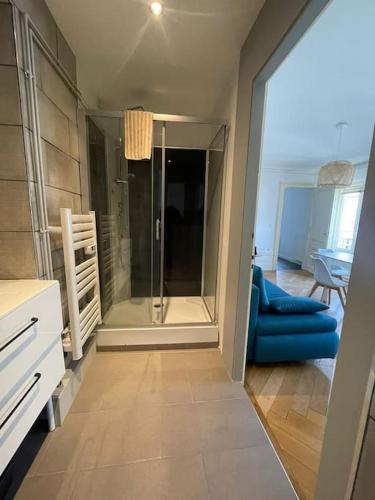 - un salon avec un canapé bleu et une porte en verre dans l'établissement Elégant 2 chambres square saint amour, à Besançon