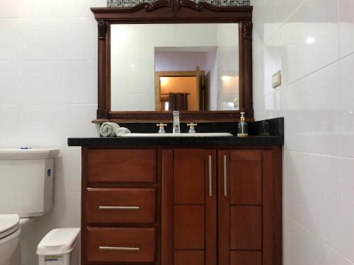 ein Badezimmer mit Waschbecken und Spiegel in der Unterkunft Villa Yisbel By Hospedify - Villa con Piscina, jacuzzi, mesa de billas, y cancha de Basketball in Jarabacoa