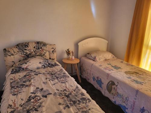 1 dormitorio con 2 camas y una mesa pequeña en Yellow House en San Rafael