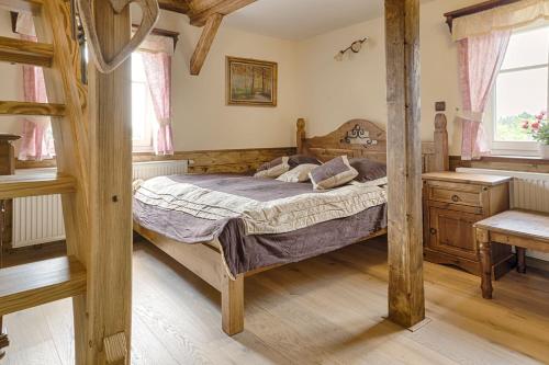 1 dormitorio con cama de madera y tocador de madera en Exkluzivní chalupa Podještědka s grilem a saunou, en Světlá pod Ještědem