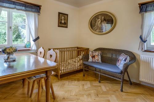 a dining room with a crib and a table and chairs at Exkluzivní chalupa Podještědka s grilem a saunou in Světlá pod Ještědem