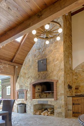 a large stone fireplace in a house with a ceiling at Exkluzivní chalupa Podještědka s grilem a saunou in Světlá pod Ještědem