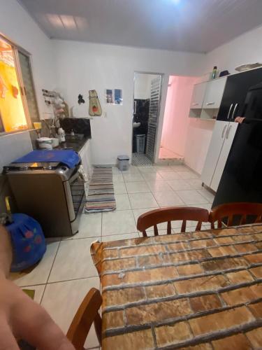 a kitchen with a table and a kitchen with a refrigerator at Mongaguá House in Mongaguá