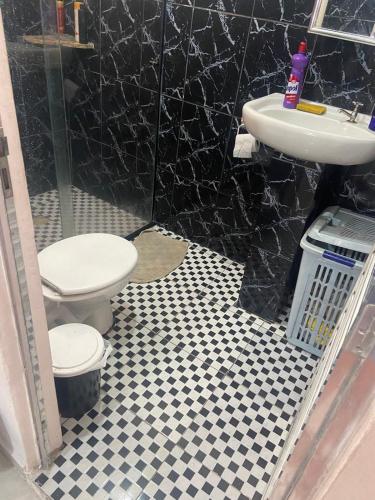 a bathroom with a toilet and a sink at Mongaguá House in Mongaguá