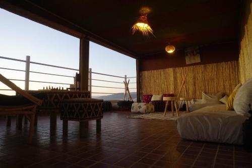 a bedroom with a bed and a view of the ocean at Caban Surf in Tamraght Ouzdar