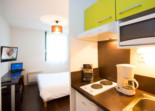 a small room with a kitchen with a blender on a counter at All Suites Appart Hôtel - Bordeaux Lac in Bordeaux