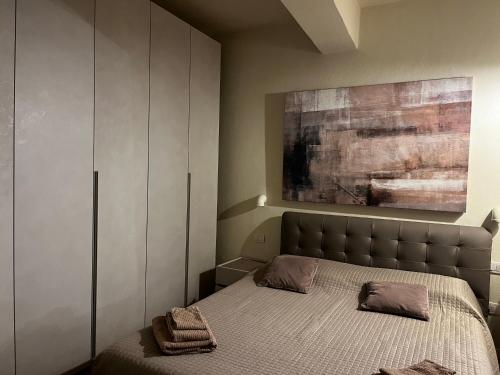 1 dormitorio con 1 cama y una pintura en la pared en Maison del Ducato Cavour 37 en Parma
