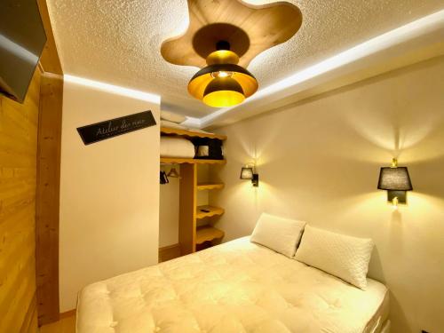 sypialnia z łóżkiem i wentylatorem sufitowym w obiekcie Appartement 2 chambres vue pistes, parking privatif w mieście Les Orres