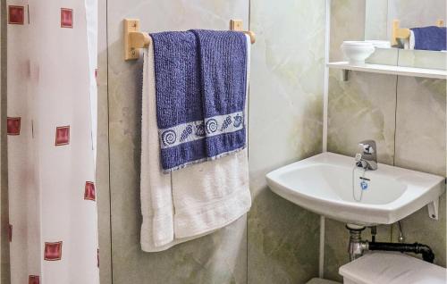 a bathroom with blue and white towels and a sink at Cozy Apartment In Agdenes With House A Mountain View in Selva