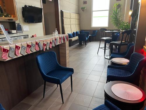 a waiting room with blue chairs and a counter at Hotel L'Oie des neiges in Lévis
